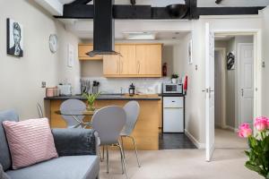 een keuken en een woonkamer met een tafel en stoelen bij Curb Properties - Super Apartment Moments From Town Centre in Cheltenham