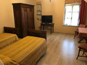 a hotel room with two beds and a television at Agriturismo la Longa in Poirino