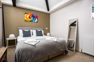 a bedroom with a large bed in a room at Curb Properties - Super Apartment Moments From Town Centre in Cheltenham