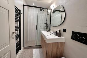 W łazience znajduje się umywalka oraz prysznic z lustrem. w obiekcie OPERA PROMENADE 2 Brand-new! 2 rooms next to the sea w Nicei