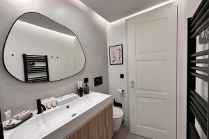W łazience znajduje się biała umywalka i lustro. w obiekcie OPERA PROMENADE 2 Brand-new! 2 rooms next to the sea w Nicei