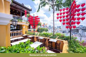een restaurant met tafels en stoelen op een balkon bij Duc Vuong Saigon Hotel - Bui Vien in Ho Chi Minh-stad