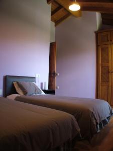 1 dormitorio con 2 camas y armario de madera en Apartamentos Rurales Vista del Sueve en Tresano