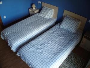 2 camas individuales en un dormitorio con paredes azules en Apartamentos Rurales Vista del Sueve en Tresano
