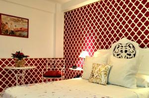 a bedroom with a bed with a red wall at Vintage apartment in Córdoba
