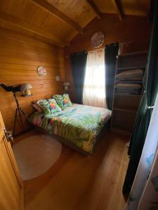 ein kleines Schlafzimmer mit einem Bett und einem Fenster in der Unterkunft Chalet de Notre Dame in Le Tampon