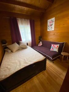 a bedroom with a bed and a couch at Chalet de Notre Dame in Le Tampon