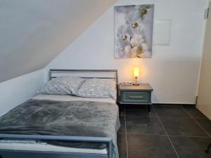 a small bedroom with a bed and a night stand at Roggendorf Zimmervermietung in Roggendorf
