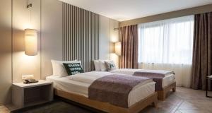 une chambre d'hôtel avec un lit et une fenêtre dans l'établissement MIA SeePark Hotel Murten, à Morat