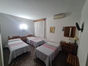 a hospital room with three beds and a window at Hotel Restaurante El Lago in Arcos de la Frontera