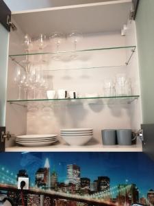 a shelf with plates and glasses on it at Apartment Tesla in Vienna