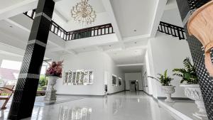 a hallway of a building with white walls and a chandelier at ทรายทอง รีสอร์ท in Ban Pru Yai +77 photos
