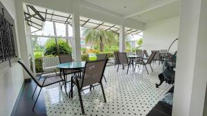 a dining room with tables and chairs on a patio at ทรายทอง รีสอร์ท in Ban Pru Yai