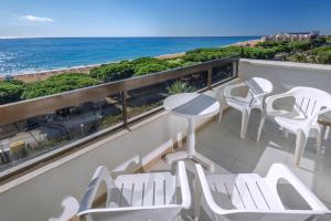 a balcony with white chairs and a view of the beach at Tropic Park in Malgrat de Mar