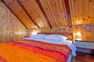Schlafzimmer mit einem großen Bett und Holzwänden in der Unterkunft Andrea in Sertić Poljana - Haus für 6 Personen in Plitvička Jezera