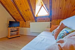 1 dormitorio con 1 cama y TV en una habitación en Andrea in Sertić Poljana - Haus für 6 Personen, en Lagos de Plitvice