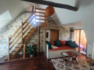 a living room with a couch and a staircase at Les Chatougoulis in Les Bordes-sur-Lez