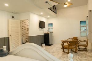 a living room with a table and a tv at ทรายทอง รีสอร์ท in Ban Pru Yai