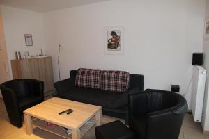 een woonkamer met een bank en 2 stoelen bij Friesenkoje in Norddeich