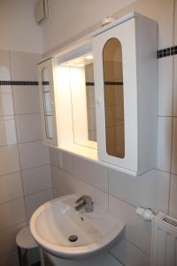 een witte badkamer met een wastafel en een spiegel bij Friesenkoje in Norddeich
