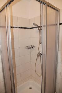 een douche met een glazen deur en een douche bij Friesenkoje in Norddeich