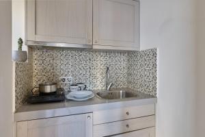 Una cocina con gabinetes blancos y un fregadero. en Prime Studio in Heraklion Center, en Heraclión