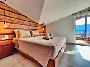 a bedroom with a large bed with a wooden wall at Meteora View Penthouse in Kalabaka