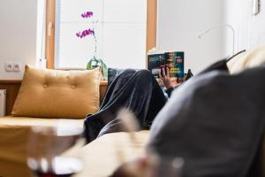 una persona seduta su un divano che legge un libro di Apart ENO a Stumm