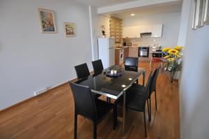 a dining room with a black table and chairs at Ithaki Phinikoudes Apartment No. 201 in Larnaka