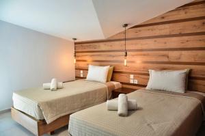 2 łóżka w pokoju z drewnianymi ścianami w obiekcie Meteora View Penthouse w Kalambace