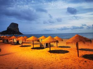 grupa parasoli na plaży z oceanem w obiekcie Deanna Magnifique villa vue mer situé à 1,5 Km de la plage w mieście Calpe