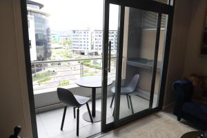 una mesa y sillas en un balcón con vistas en 418 Menlyn Maine Trilogy, en Pretoria