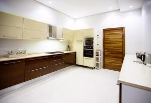 a large kitchen with wooden cabinets and appliances at Rushmore - Paradise Room in Lagos