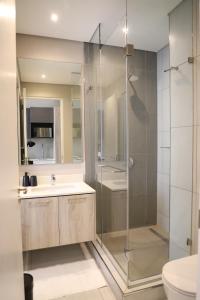 uma casa de banho com um chuveiro, um lavatório e um WC. em 418 Menlyn Maine Trilogy em Pretoria