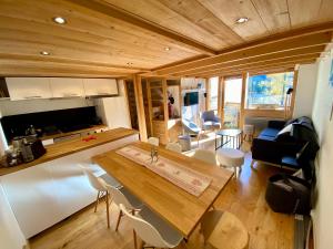 eine Küche und ein Wohnzimmer mit einem Tisch und Stühlen in der Unterkunft Residence Grand Roc - Kercham in Chamonix-Mont-Blanc