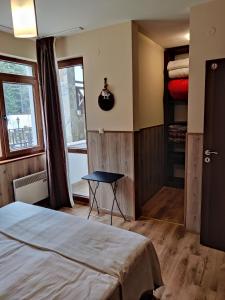 a bedroom with a bed and a table and a window at Iv Apartment in The Wonderful Rhodope Mountain in Smolyan