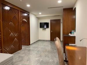 a room with a table and chairs and a television at Hotel Hyderabad Grand in Shamshabad