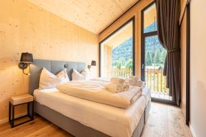 a bedroom with a bed and a large window at Alpenchalets Biberwier Zugspitze by ALPS RESORTS in Biberwier