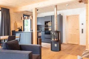 a kitchen and a living room with a stove at Alpenchalets Biberwier Zugspitze by ALPS RESORTS in Biberwier