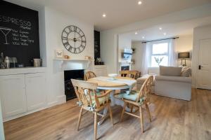 a dining room and living room with a table and chairs at Lemon Cottage- Stylish & Modern Home - Town Centre in Newton Abbot