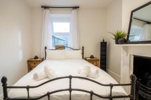 a bedroom with a bed with a fireplace and a mirror at Lemon Cottage- Stylish & Modern Home - Town Centre in Newton Abbot
