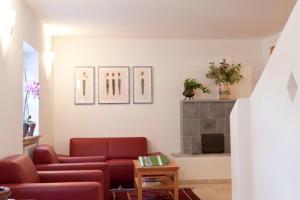 salon z czerwoną kanapą i kominkiem w obiekcie Lienharterhof w mieście Monguelfo