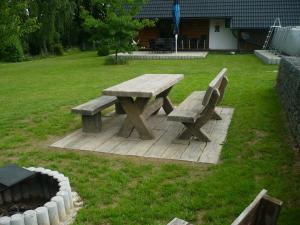a wooden picnic table and bench in a yard at Chalupa u Alunka in Police nad Metují