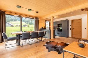 a kitchen and dining room with a table and chairs at Alpenchalets Biberwier Zugspitze by ALPS RESORTS in Biberwier