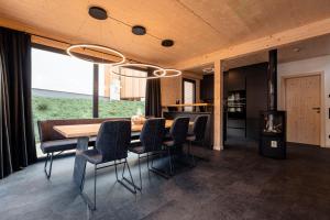 a dining room with a wooden table and chairs at Alpenchalets Biberwier Zugspitze by ALPS RESORTS in Biberwier
