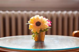 Hotel Villani في فلورنسا: مزهرية صغيرة مع وردة على طاولة