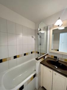 y baño con lavabo, bañera y espejo. en Casa Alessia - Villefranche-sur-mer en Villefranche-sur-Mer