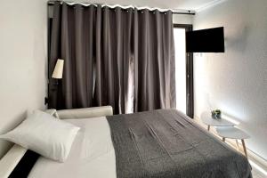 1 dormitorio con cama blanca y ventana en Casa Alessia - Villefranche-sur-mer en Villefranche-sur-Mer