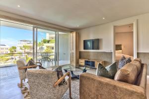a living room with a couch and chairs and a tv at Two Bedroom Apartment - fully furnished and design in Va Marina Residential in Cape Town