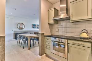 a kitchen with a table and a dining room at Two Bedroom Apartment - fully furnished and design in Va Marina Residential in Cape Town